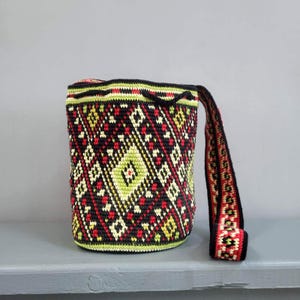 Back view of Ukrainian folk crochet shoulder bag showing geometric pattern and long patterned strap.
