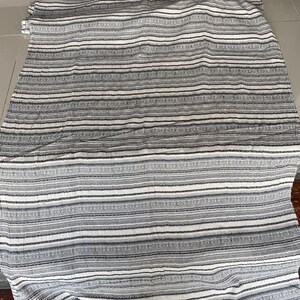 May include: White and gray striped fabric with a subtle pattern. The fabric has a soft, textured feel.
