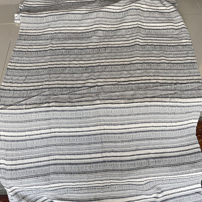 May include: White and gray striped fabric with a subtle pattern. The fabric has a soft, textured feel.