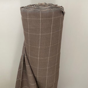 May include: A roll of brown fabric with a white grid pattern.