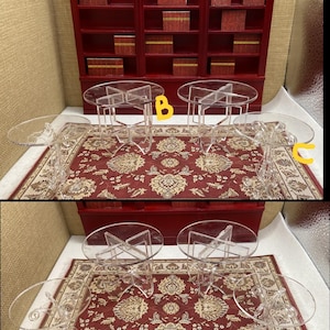 Puede incluir: Juego de muebles en miniatura para casa de muñecas. Incluye una estantería roja con pequeñas cajas y mesas de acrílico transparente con tapas ovaladas. Las mesas están sobre una alfombra estampada roja y crema.