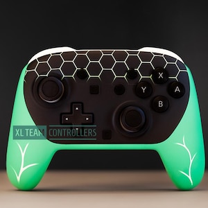 Könnte beinhalten: Ein individueller Videospiel-Controller mit einem schwarzen Mittelteil und mintgrünen Griffen. Die Oberseite hat ein Wabenmuster und die Griffe ein weißes Blattdesign. Der Controller hat schwarze Tasten und den Text "XL TEAM CONTROLLERS".
