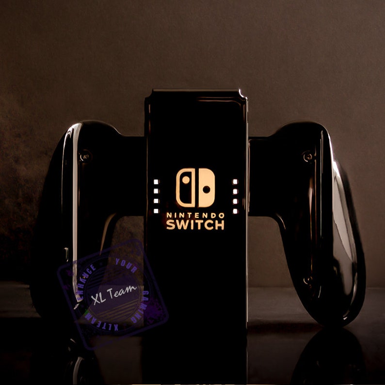 May include: Black Nintendo Switch console with black Joy-Con controllers. The console has a white Nintendo Switch logo and the text "NINTENDO SWITCH" on the front.