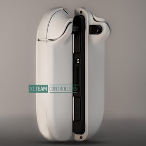 May include: A white gaming controller with black accents, featuring a sleek design. The controller has a curved shape and visible buttons and ports. The text "XL TEAM CONTROLLERS" is printed on the side.