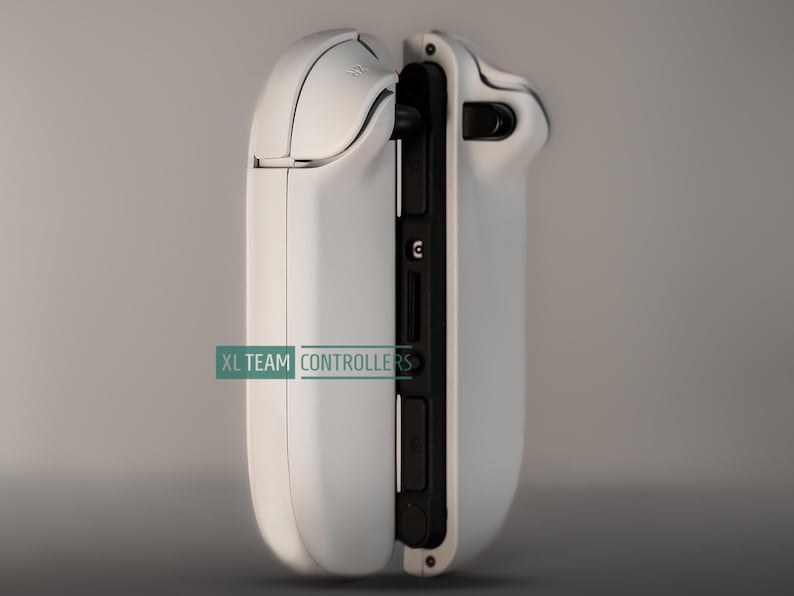 May include: A white gaming controller with black accents, featuring a sleek design. The controller has a curved shape and visible buttons and ports. The text "XL TEAM CONTROLLERS" is printed on the side.
