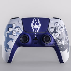 May include: A custom-designed PlayStation 5 DualSense controller with a white and blue color scheme. The controller features a white dragon symbol on the top and a white dragon design on the sides. The controller is a popular choice for gamers who want to personalize their gaming experience.
