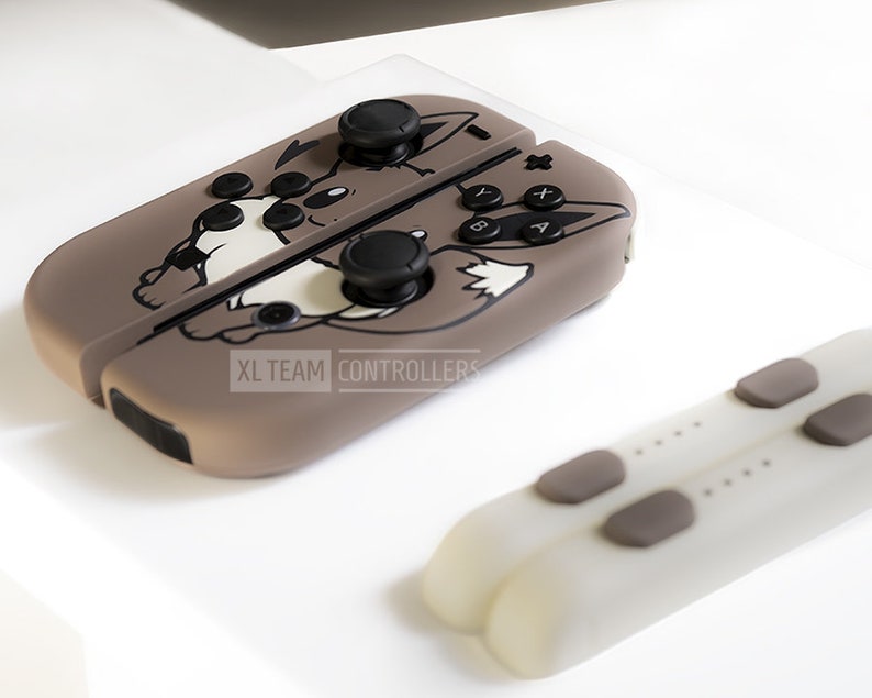 May include: A set of brown and white game controllers with a cartoon wolf design. The controllers have black buttons and joysticks. The text "XL TEAM CONTROLLERS" is visible on the side of the controller.