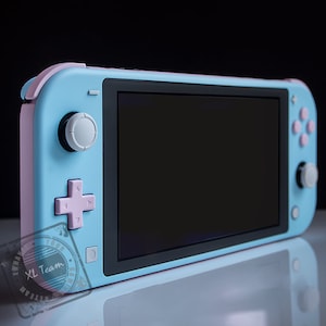 May include: A light blue Nintendo Switch Lite handheld gaming console with pink buttons and a black screen. The console has a white joystick on the left and a white button on the right.