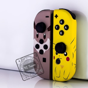 May include: A pair of Nintendo Switch Joy-Con controllers with custom skins. The left Joy-Con features a brown and white Eevee design, while the right Joy-Con features a yellow Pikachu design.