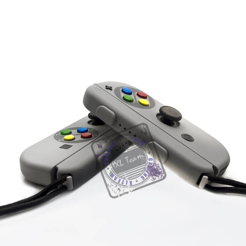 May include: Two gray Nintendo Switch controllers with black straps. The controllers have a classic Super Nintendo design with colored buttons and a black joystick.