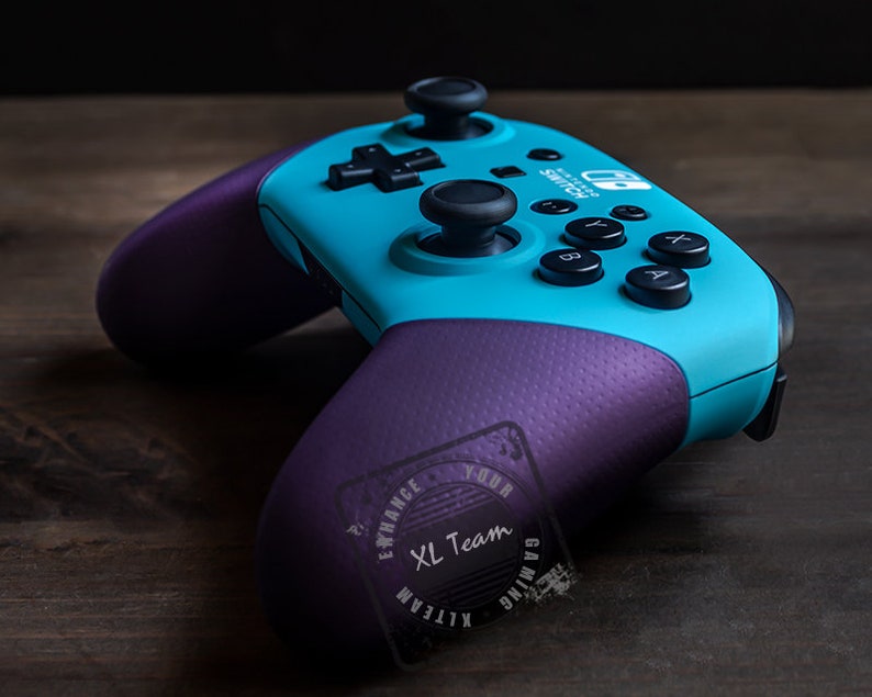 May include: A teal and purple Nintendo Switch controller with the text "Nintendo Switch" printed on the top. The controller has a purple XL Team Gaming logo on the back.