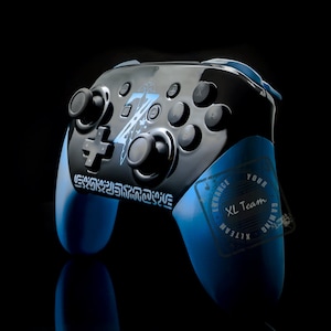 Könnte beinhalten: Ein blauer und schwarzer Nintendo Switch-Controller mit einem Zelda-Design und einem "Enhance Your Gaming XL Team" Stempel.