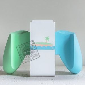 May include: A white controller stand with a green and blue controller on each side. The stand has a design of a palm tree and an island on the front. The text "XL Team" is visible on the green controller.