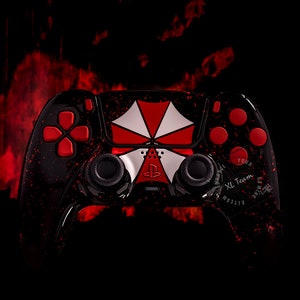 May include: A black PlayStation 5 controller featuring a red and white Umbrella Corporation logo. The controller has red buttons and a black and red splatter paint design. The text "Your XL Team" is printed on the controller.