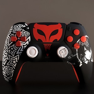 May include: A black and red custom PlayStation 5 controller with a white star pattern on the left side, a red and black mask design on the front, and a black and white anime character on the right side. The controller has red buttons and white analog sticks.
