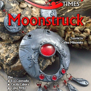 May include: A silver and red necklace with a large, ornate pendant. The pendant has a red gemstone in the center and is surrounded by intricate silver designs. The necklace is hanging from a wooden surface. The text "Moonstruck" is written in red letters above the necklace. The text "Artisan Jewelry Times" is written in black letters above the text "Moonstruck". The text "August 2017" is written in black letters above the text "Artisan Jewelry Times". The text "Tutorial by Galina Milusenko" is written in black letters below the necklace. The text "Plus... Éva Csizmadia Cecilia Labora Tanja Perko Emily Kline ... And Much More!" is written in black letters on the right side of the image.