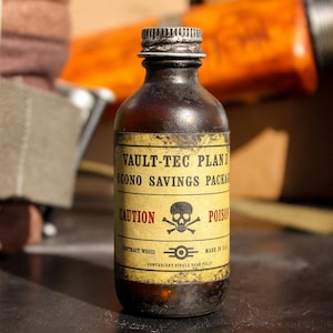 Könnte beinhalten: Eine braune Glasflasche mit einem gelben Etikett, auf dem "VAULT-TEC PLAN D ECONO SAVINGS PACKAGE" und "CAUTION POISON" steht. Das Etikett enthält auch ein Totenkopf- und Knochenkreuz sowie den Text "CONTRACT WS021" und "MADE IN U.S.A."