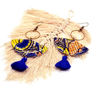May include: A pair of colorful earrings with blue, yellow, and orange geometric patterns. The earrings have a gold hoop and a blue tassel.