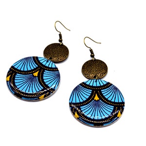 May include: A pair of blue and gold earrings with a geometric pattern. The earrings are made of wood and have a brass accent.