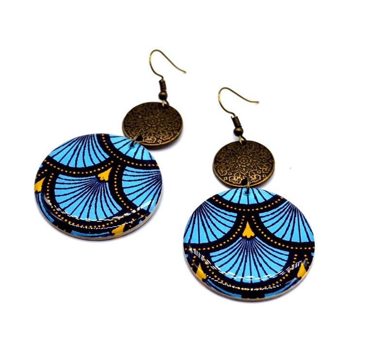 May include: A pair of blue and gold earrings with a geometric pattern. The earrings are made of wood and have a brass accent.