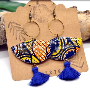 May include: A pair of colorful earrings with blue, yellow, orange, and brown geometric patterns. The earrings have gold hoops and blue tassels.