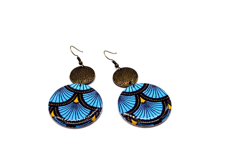 May include: A pair of blue and gold earrings with a geometric pattern. The earrings are made of wood and have a brass accent.