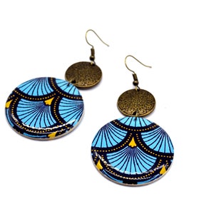 May include: A pair of blue and gold earrings with a geometric pattern. The earrings are made of wood and metal.