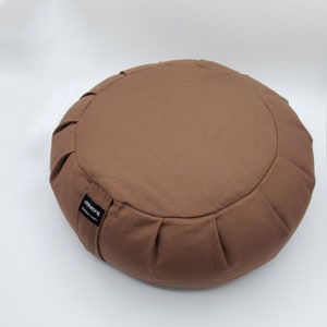 May include: A brown meditation cushion with a black label that says "stellating" and "meditation support".