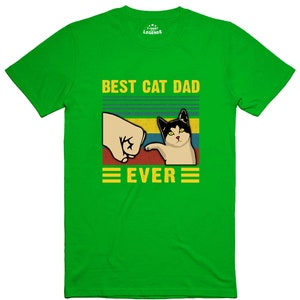 May include: Green t-shirt with a retro-style graphic that says "Best Cat Dad Ever". The graphic features a fist bumping a cat.