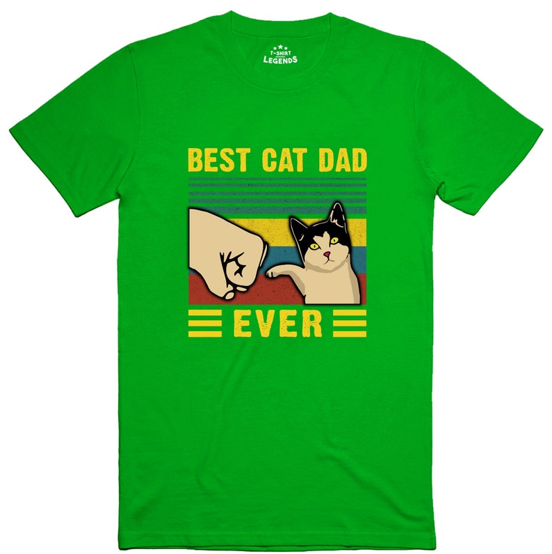 May include: Green t-shirt with a retro-style graphic that says "Best Cat Dad Ever". The graphic features a fist bumping a cat.