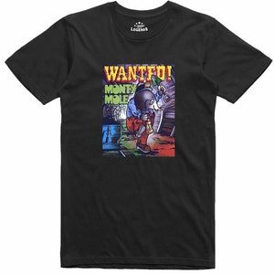 May include: Black t-shirt with a cartoon illustration of a mole holding a pickaxe and lantern, with the words "WANTED!" and "MONTY MOLE". The shirt has a crew neck and short sleeves. The T-shirt Legends logo is in the upper right corner.