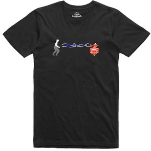 May include: Black t-shirt with a pixelated graphic of a video game character pulling a chain attached to a red and pink object. The text "T-SHIRT LEGENDS" is printed on the shirt.