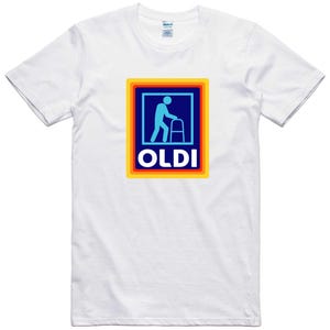May include: White t-shirt with a colorful logo featuring a blue silhouette of a person walking with a walker and the word "OLDI" in blue letters.
