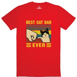 May include: Red t-shirt with a retro-style graphic that says "Best Cat Dad Ever" with a cat giving a fist bump.