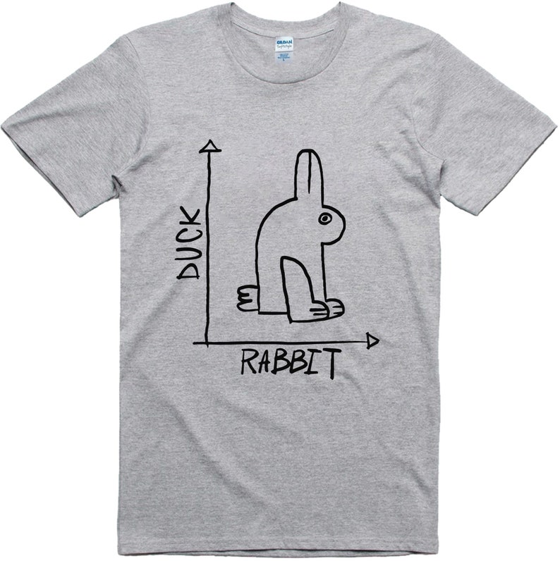 May include: A light gray t-shirt featuring a black line drawing of a rabbit, with the words "DUCK" and "RABBIT" labeling the axes of a graph. The rabbit illustration is minimalist and whimsical.