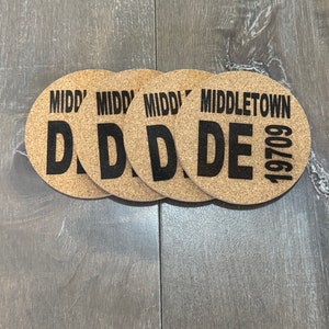 May include: Four brown cork coasters with black text. The coasters feature the word "MIDDLETOWN" and the year "1970" on one coaster. The other three coasters feature the word "MIDDLE" with a large letter "D" on each.