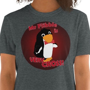 May include: A dark heather grey t-shirt with a red circle graphic featuring a cartoon penguin wearing a red bow tie. The text "Mr. Flibble is very cross!" is written in red around the penguin.