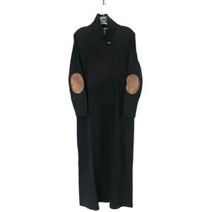 May include: A long black dress with long sleeves and a collared neckline. The dress features brown elbow patches and a button closure at the neckline. The dress is hanging from a metal hanger.