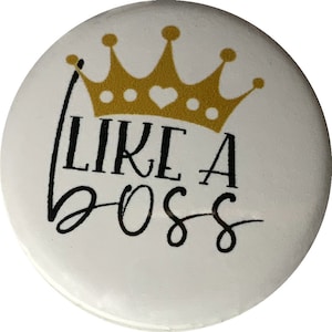 May include: White button with a gold crown and the text "Like a Boss" in black script.