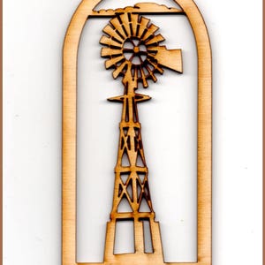 May include: Wooden cutout of a windmill with a brown finish. The windmill is in a rectangular frame with a rounded top. The text "Windmill # 735" is at the bottom of the frame.