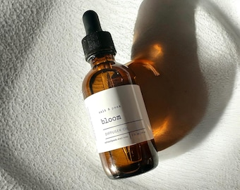 May include: A brown glass diffuser oil bottle with a black dropper. The label reads "salt & peak bloom DIFFUSER OIL". The bottle is 2 fl oz / 59 ml. The bottle is on a white textured surface.