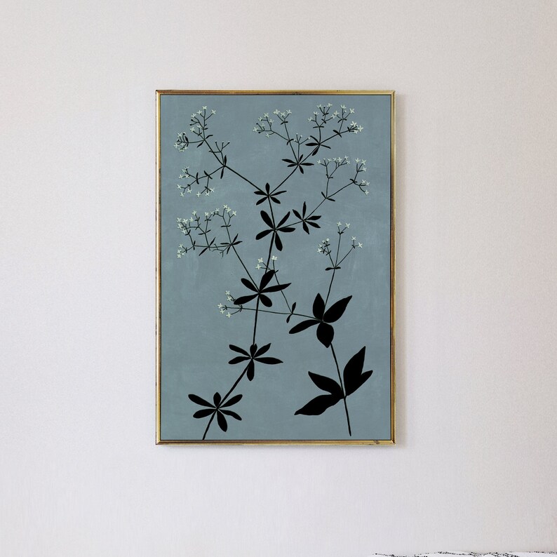 May include: A framed print of a botanical illustration featuring a black silhouette of a plant with white flowers on a light blue background.