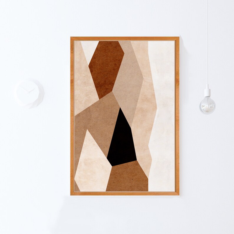 May include: Abstract geometric art print in a wooden frame. The print features a design of overlapping shapes in shades of brown, beige, and black.