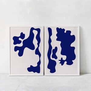 May include: Two framed prints featuring abstract shapes in a dark blue colour on a white background.