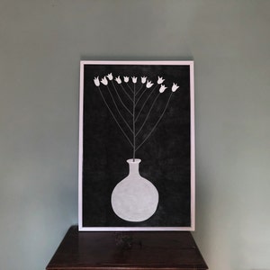 May include: A black and white illustration of a vase with white flowers on a black background. The vase is round and has a short neck. The flowers are simple and stylized.