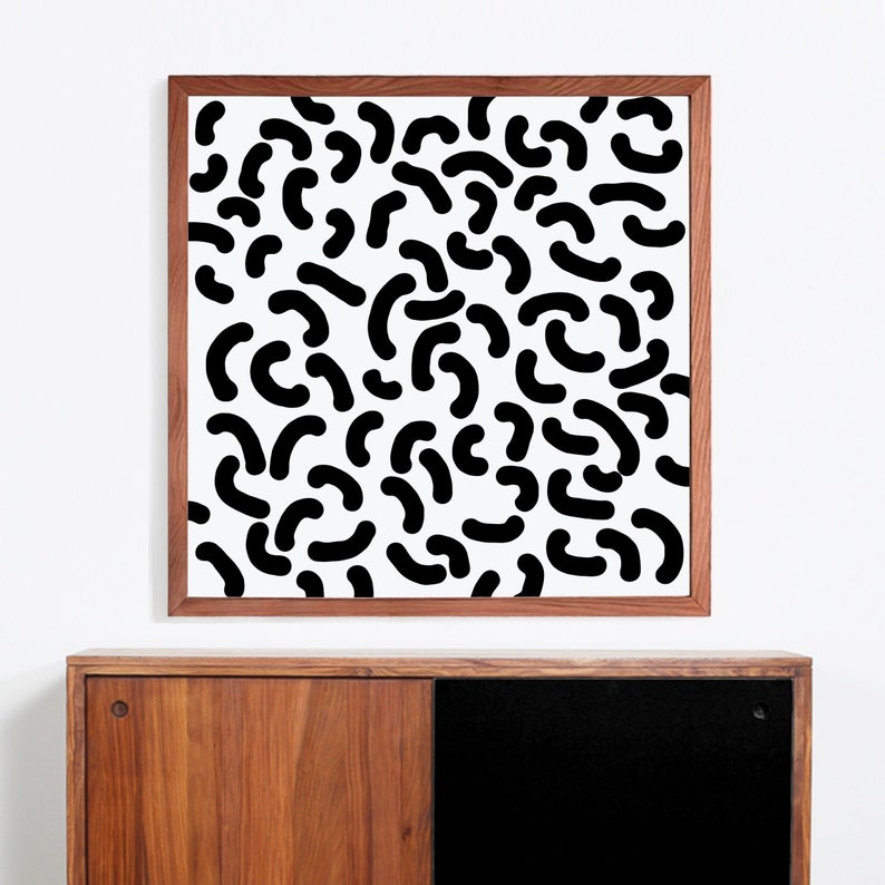 Puede incluir: Una impresi&oacute;n abstracta en blanco y negro enmarcada con un patr&oacute;n de formas curvas. La impresi&oacute;n est&aacute; en un marco de madera.