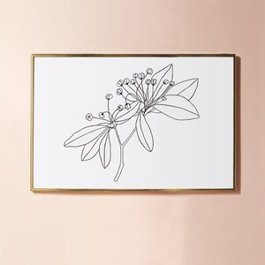 May include: A black and white line drawing of a flowering branch with leaves. The drawing is framed in a gold frame and is hanging on a light pink wall.