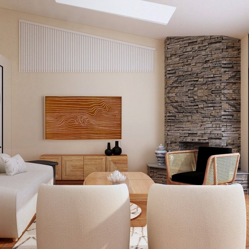 May include: A living room with a stone fireplace, a white couch, a coffee table, and two chairs. The fireplace has a black mantel and a black and white rug in front of it. There is a large abstract painting on the wall above the couch.