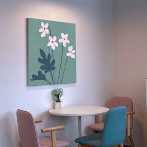 May include: A teal green canvas print with a stylized floral design featuring white flowers with orange centers and dark blue leaves.