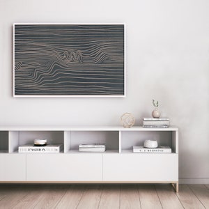 May include: A white media console with three shelves, featuring books and decorative objects. A framed abstract art print with gold lines on a dark background hangs above the console.
